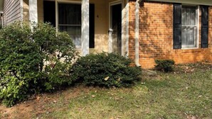 A single-story house with a brick facade, a covered porch with white columns, and a chimney. - Down Home Comfort - Greenville, SC

 (Piedmont)