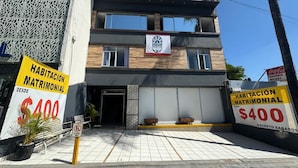 Ein modernes Gebäude mit einem Schild, das Ehelosigkeit-Unterkünfte zu 400 Dollar ohne Sonntage anbietet.