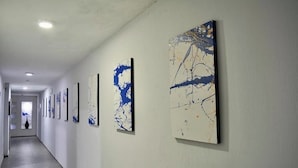 Ein Flur mit mehreren Kunstwerken an den Wänden.