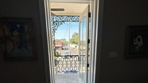 An open doorway leading to a balcony with a metal railing.