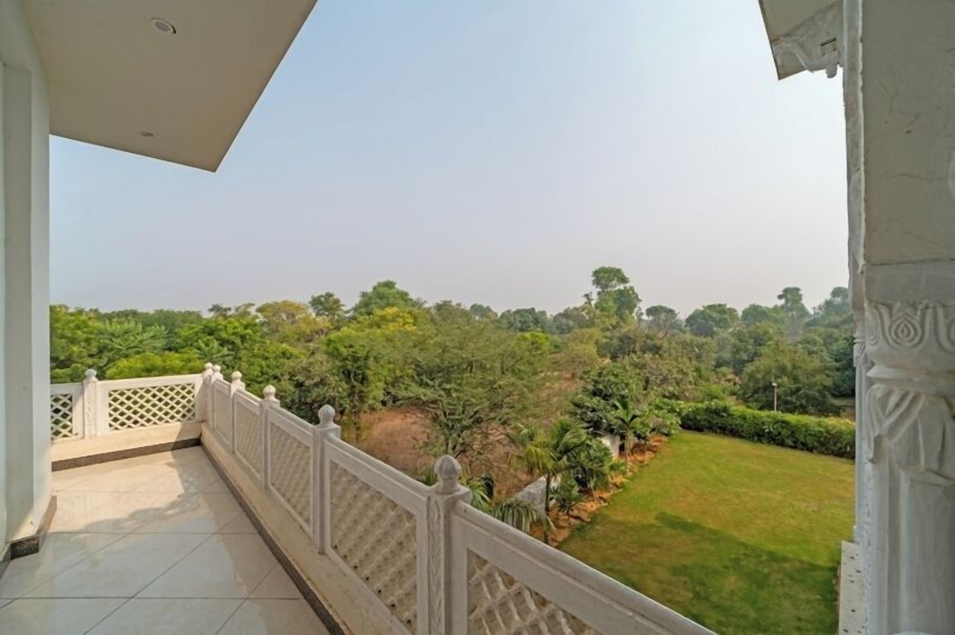 A balcony with a view of a lush green landscape.