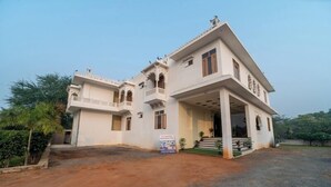 A two-story building with a flat roof, multiple balconies, and a central entrance with steps. - Joy Bagh Resort  (Pushkar)