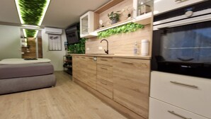 Una cocina compacta con horno integrado, armarios de madera y una pequeña encimera.