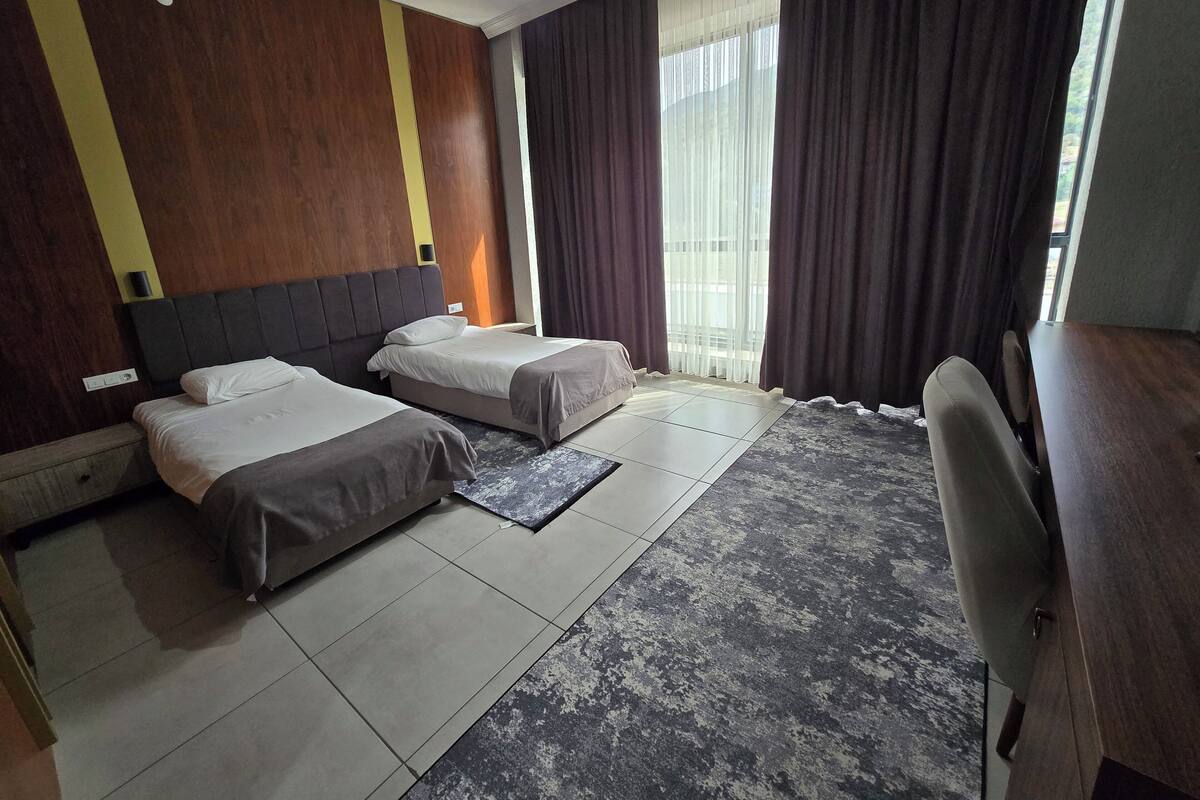 Een hotelkamer met twee bedden, een bureau en een stoel.