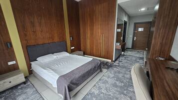 Un dormitorio con cama, armario de madera y tocador con espejo.