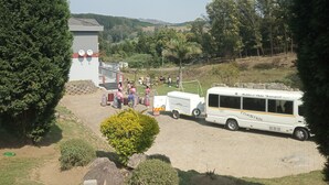 A bus parked in a parking area with a building in the background. - Haven guesthouse nkoyoyo (Mbabane)