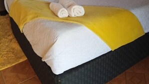 A hotel room with two beds, each with white linens and yellow accents. - Haven guesthouse nkoyoyo (Mbabane)