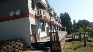 A multi-story building with balconies, a staircase, and satellite dishes. - Haven guesthouse nkoyoyo (Mbabane)