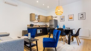 Eine moderne Küche mit Holzschränken, einem eingebauten Ofen und einem Essbereich mit blauen Stühlen und einem Tisch.