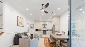 A modern kitchen with white cabinets, a dining table, and a ceiling fan. - Hook, Wine, Sinker Unit B (Winchester)