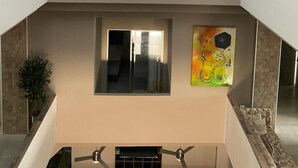 A multi-level interior with artwork on the walls, a staircase, and a seating area. - Hotel Panorama  (El Banco)