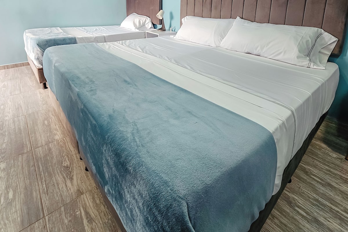 Un dormitorio con dos camas, un ventilador de techo y un letrero en la pared que dice "Panorama".
