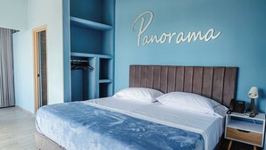 A bedroom with a bed, a nightstand, a wardrobe, and a wall with the word "Panorama". - Hotel Panorama  (El Banco)
