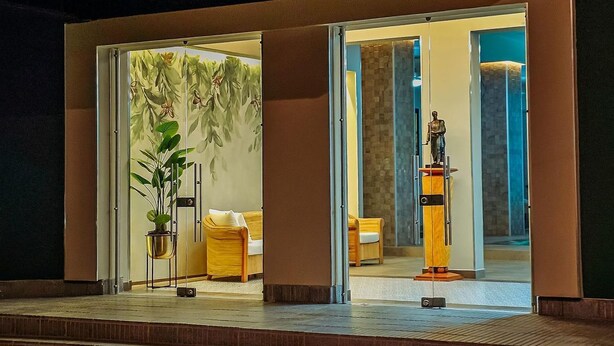 A modern hotel lobby with a reception desk, seating area, and a statue. - Hotel Panorama  (El Banco)