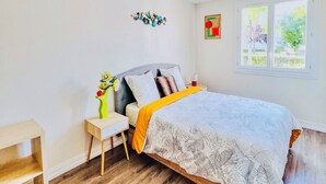 Une chambre à coucher avec un lit, une table de chevet et une fenêtre.