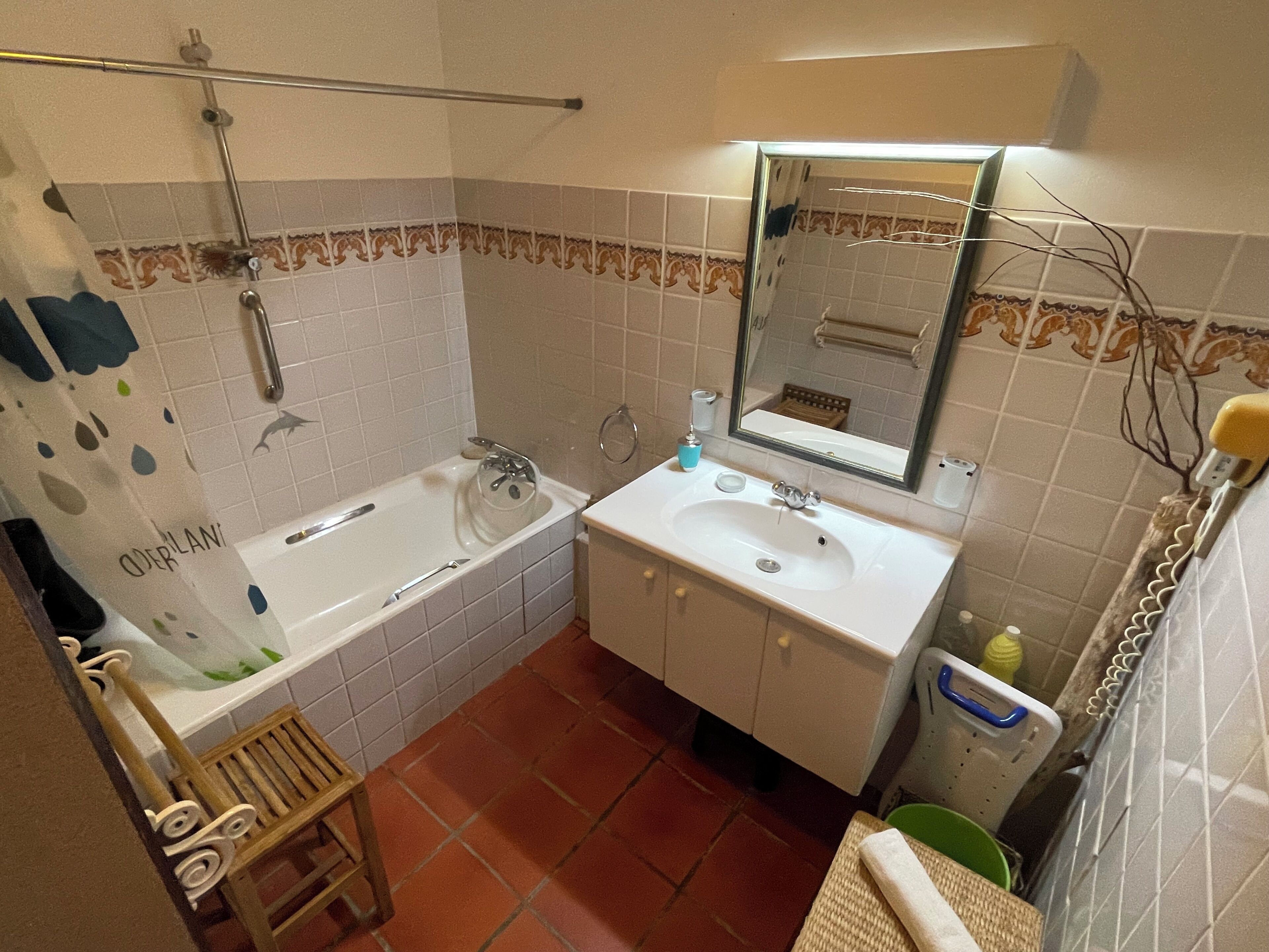 A bathroom with a bathtub, a sink, a mirror, and a shower.