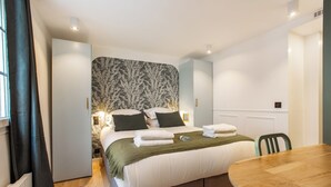 Un dormitorio moderno con una cama grande, una mesa de comedor de madera y un cabecero estampado.