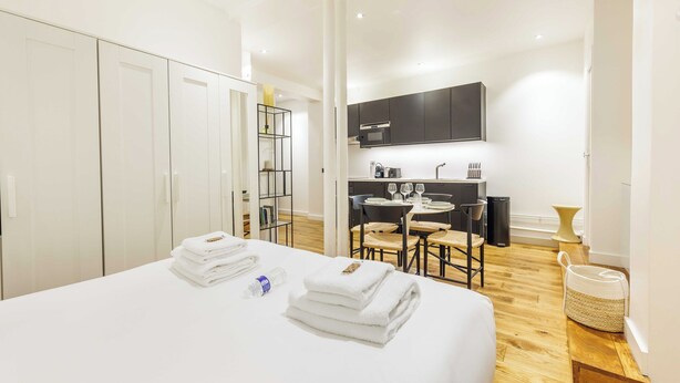 A hotel room with a bed, a small kitchenette, and a dining area. - Cosy Apartment - 1br/4p - Near Champs-elysees (Paris)