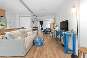 Un salon moderne avec un canapé, une table basse et un téléviseur.