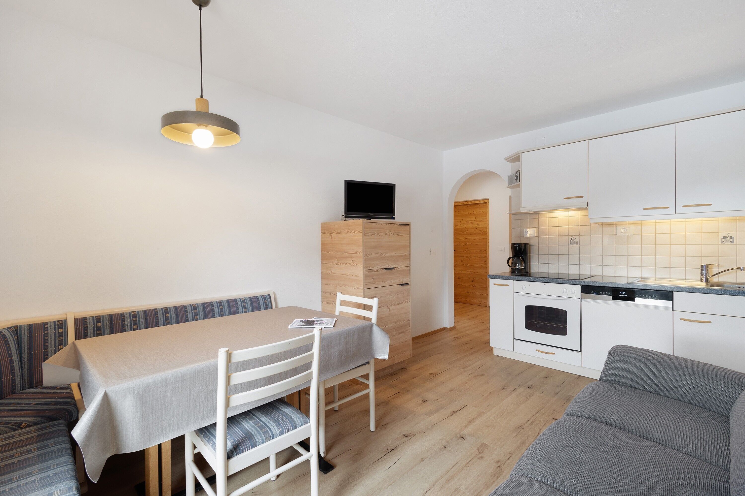 A modern kitchen with white cabinets, a built-in oven, and a dishwasher.