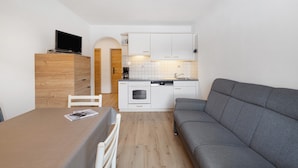 Een knus verblijf met kitchenette, een eethoek en een slaapbank.