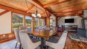 A spacious dining area with a wooden ceiling and large windows overlooking a mountainous landscape. - Wapato Point Escape: Private Hot Tub • Walk to Beach • Lake Views (Manson)