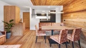 A modern interior with a wooden ceiling, a dining area with patterned chairs, a wooden bench, and a potted plant. - Apartment 'Paradeis Apartments A19' with Mountain View, Private Terrace and Wi-Fi (Mühlbach)