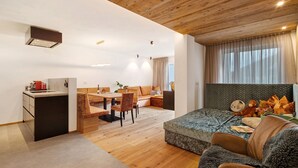 A modern interior with a wooden ceiling, a dining area, a sofa with cushions, and a small table. - Apartment 'Paradeis Apartments A17' with Mountain View, Balcony and Wi-Fi (Mühlbach)