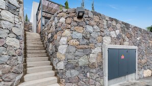 Un muro de piedra con una escalera que conduce a una puerta marcada con el número 14.