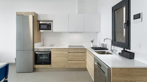 Una cocina moderna con electrodomésticos de acero inoxidable, armarios de madera y un amplio ventanal.