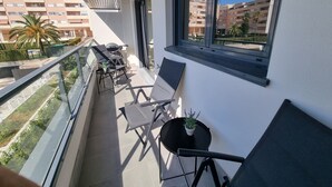 A balcony with a table, chairs, and a potted plant. - Apartment 'New 3 Bed Family Suite In Mijas' with Wi-Fi and Air Conditioning (Las Lagunas de Mijas)