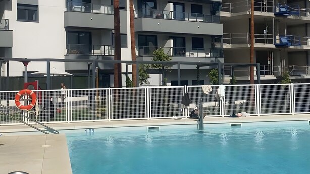 A modern hotel with a swimming pool, multiple balconies, and palm trees. - Apartment 'New 3 Bed Family Suite In Mijas' with Wi-Fi and Air Conditioning (Las Lagunas de Mijas)