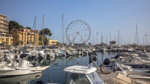A marina with numerous boats docked, a Ferris wheel in the background, and buildings along the waterfront. - Mobile Home 'Camping Lou Soulei 218' with Sea View, Shared Pool and Air Conditioning (Carry-le-Rouet)