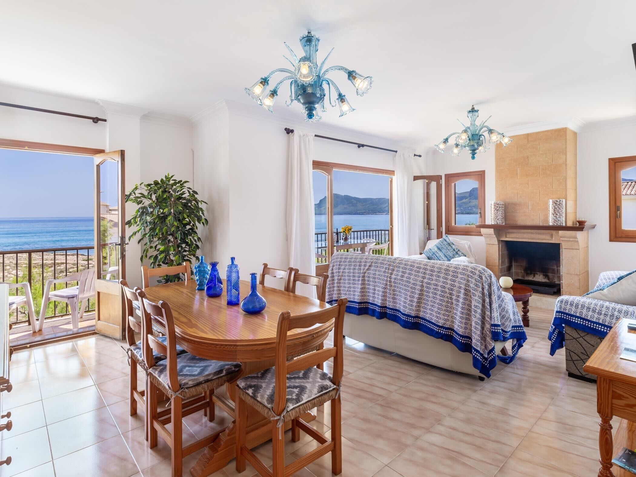 A spacious living area with a dining table, chairs, a sofa, and a fireplace.