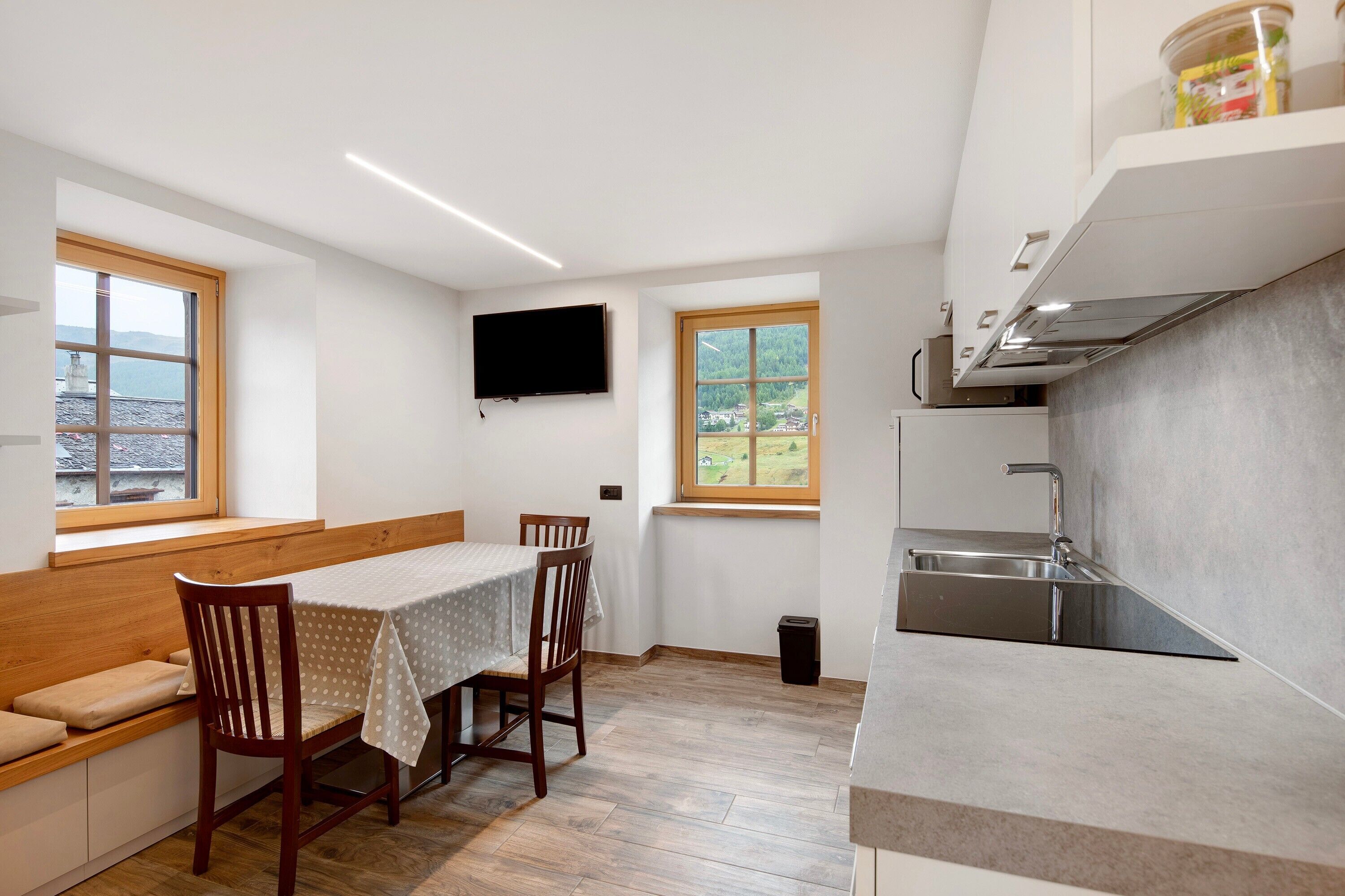 A compact kitchen with a built-in stove, a sink, and a window overlooking a scenic view.
