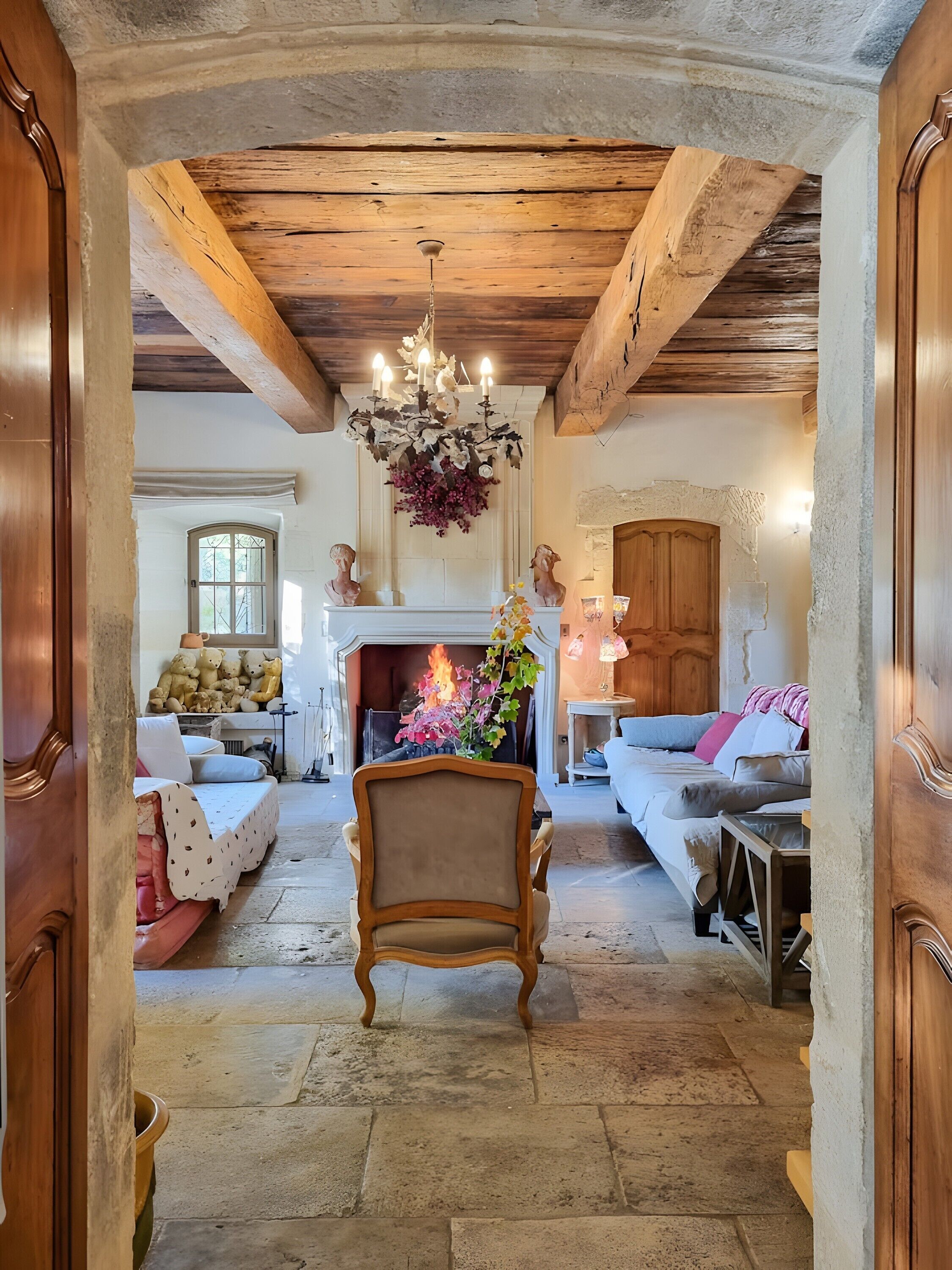 Un intérieur rustique avec des poutres apparentes, une cheminée et un lustre.