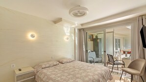 A bedroom with a bed, a chair, a desk, and a television.
