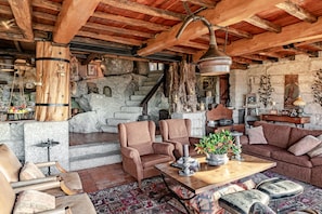 A rustic interior with wooden beams, stone walls, a fireplace, and traditional furnishings. - Holiday Home 'Casa Do Gêres' with Lake View, Private Pool and Wi-Fi (Gêres)