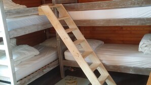 A bunk bed room with a wooden ladder.