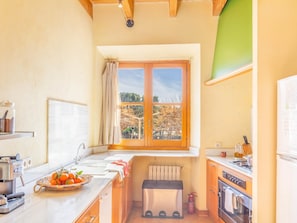 Une cuisine avec une fenêtre, une cuisinière, un évier et une machine à café.