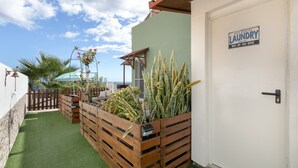 A laundry room with a sign, wooden planters with plants, and a door. - Vacation Studio 'Azahares 1 Estudio' with Sea View, Private Terrace and Wi-Fi (Candelaria)
