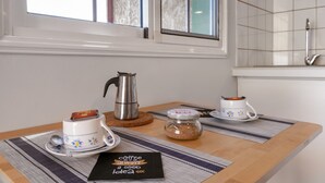 A kitchen area with a coffee setup including a kettle, two cups, a spoon, a jar, and a placemat with a coffee-themed message. - Vacation Studio 'Azahares 1 Estudio' with Sea View, Private Terrace and Wi-Fi (Candelaria)