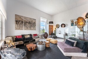 Una sala de estar moderna con un sofá, una mesa de centro y una obra de arte en la pared.
