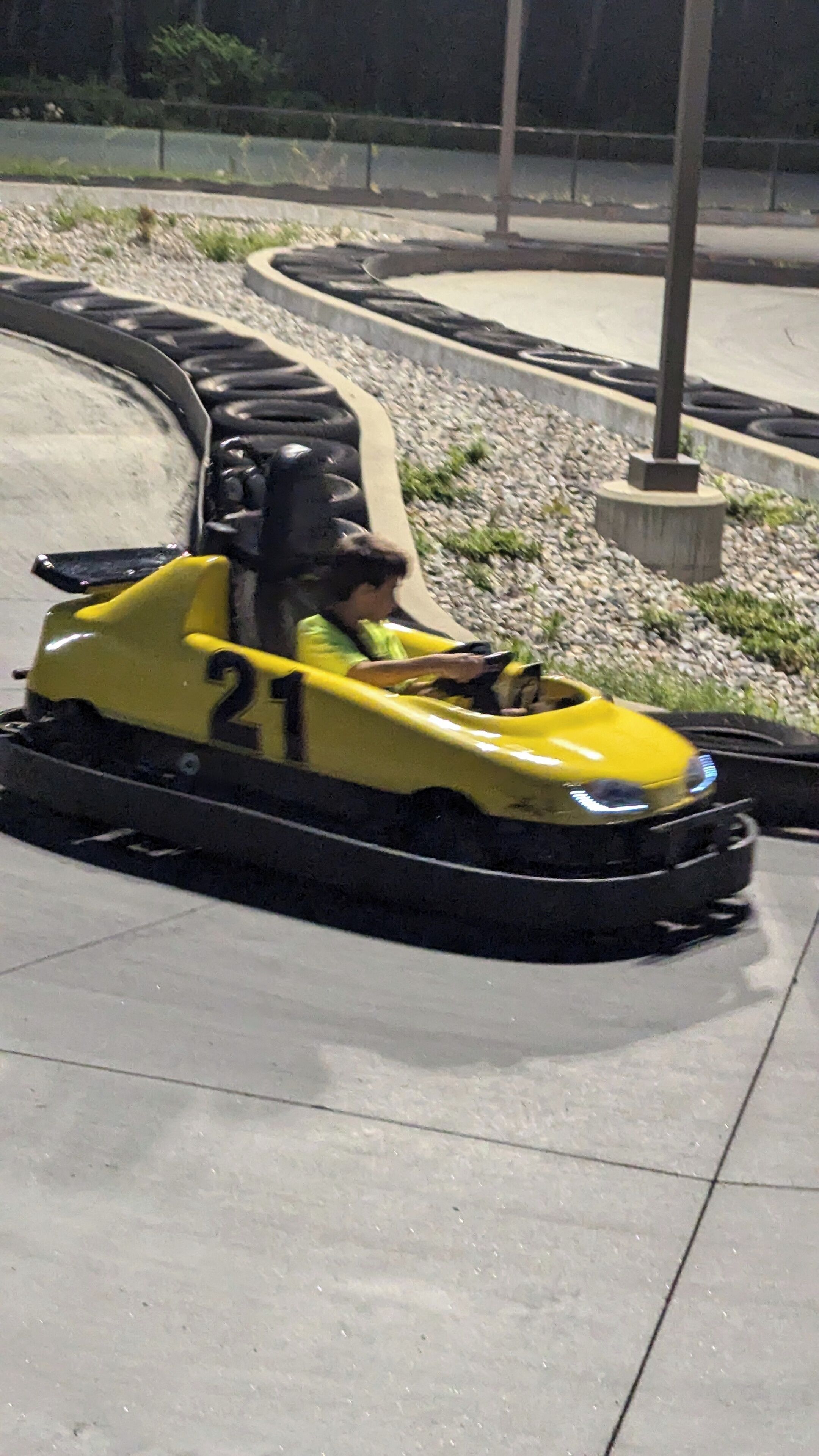 A yellow bumper car with the number 21 on it.