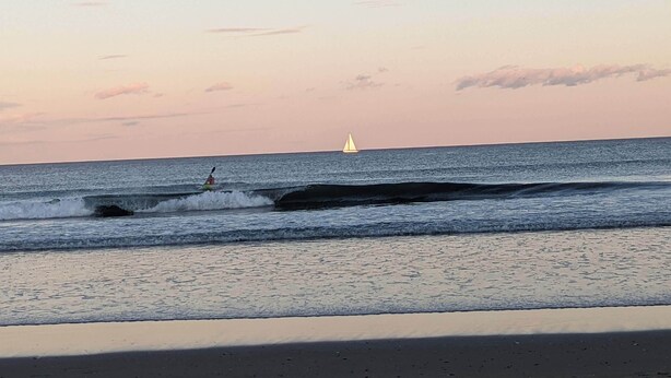 A beach with waves and a sailboat in the distance. - Walk or Bike to Moody Beach (Wells)
