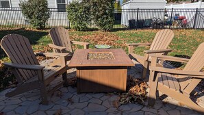 A patio with a square table and four Adirondack chairs. - Walk or Bike to Moody Beach (Wells)