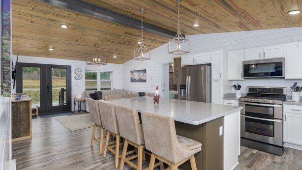 A modern kitchen with a large island, stainless steel appliances, and wooden ceiling. - Welcome Hunters! Next to Garrity Mtn Wildlife Area (Anaconda)