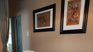 Un comedor con una mesa redonda, dos sillas y un cuadro en la pared.