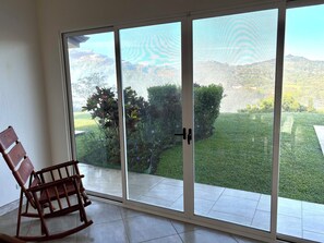 Enjoy the serene view from your outdoor space, complete with a comfortable rocking chair.