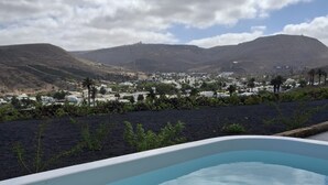 Una piscina con vistas a un pueblo y montañas al fondo.